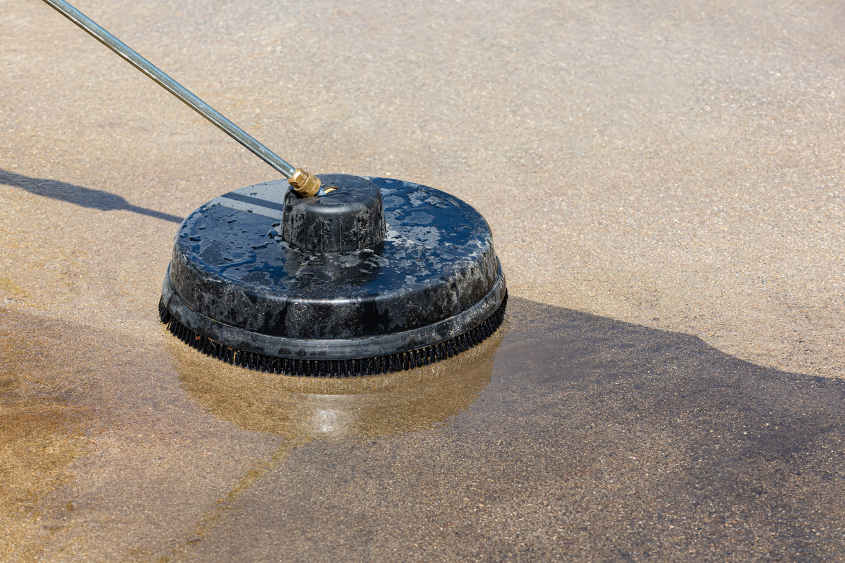 Pressure washing and cleaning dirty concrete driveway. Home cleaning, maintenance and household chores concept